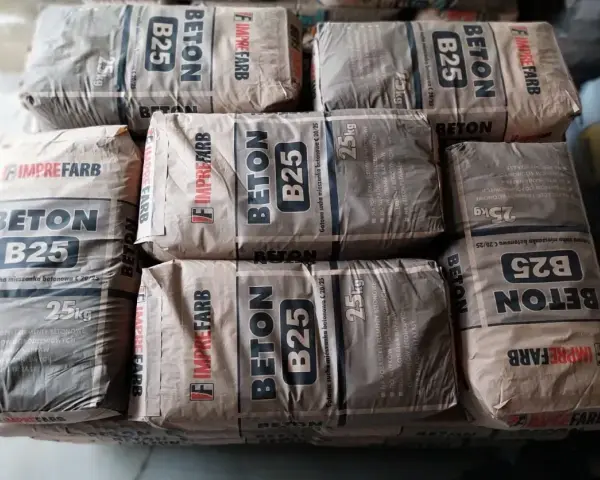 Sztaplowane worki z betonem B25, każdy po 25 kg. Wiedząc, ile waży kubik betonu, można oszacować potrzebną ilość materiału.