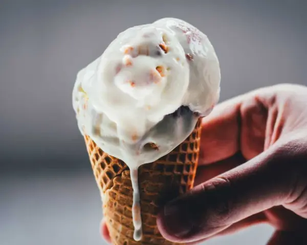Eine Hand hält ein schmelzendes Rhabarber-Eis in einer Waffel.