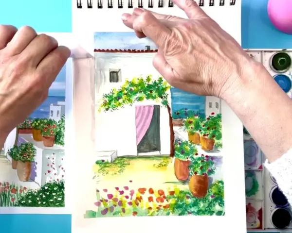 Manos pintando acuarelas fáciles de hacer: un patio con flores y una casa blanca.