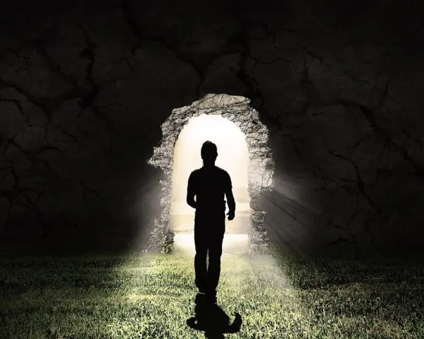 Ein Mann im Schatten tritt aus einer Höhle ins Licht. LK 21.
