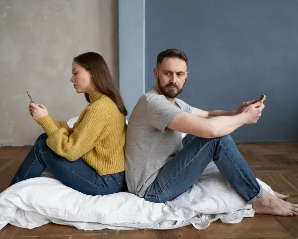 Para siedzi plecami do siebie, wpatrzona w telefony. Czy to przykład breadcrumbing co to znaczy?