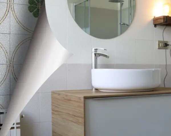 Un bagno anni '70 con piastrelle floreali verdi e un moderno lavabo.