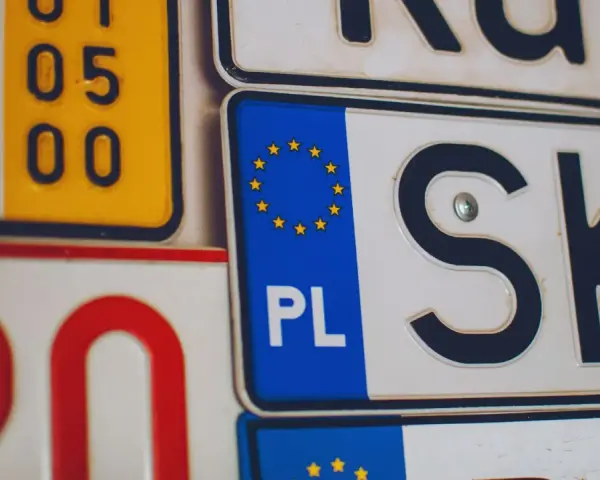 Kolekcja tablic rejestracyjnych, w tym polska z symbolem UE i oznaczeniem PL.