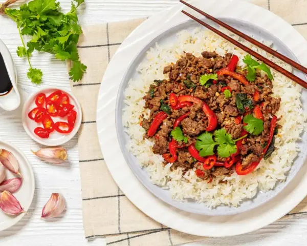 Delicioso arroz con carne picada, pimientos rojos y cilantro fresco. Acompañado de salsa de soja, chiles y ajos.