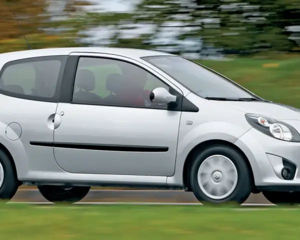 Srebrne Renault Twingo 2 w ruchu, z rozmytym tłem zieleni i drzew.