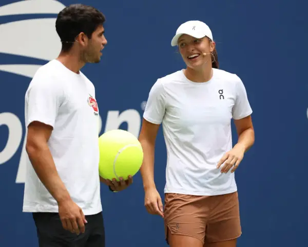 Carlos Alcaraz i Iga Świątek rozmawiają podczas Roland Garros 2024. Carlos trzyma wielką piłkę tenisową.