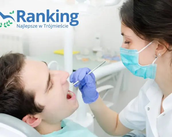 Dentystka w masce bada zęby pacjenta narzędziem stomatologicznym.