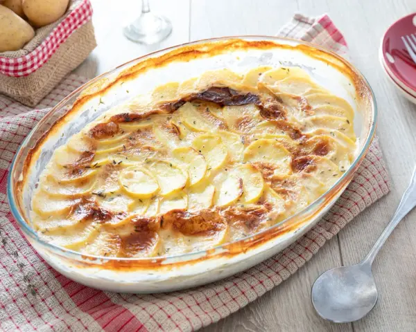 Un gratin dauphinois doré et crémeux, digne d'une recette de Cyril Lignac, prêt à être dégusté.