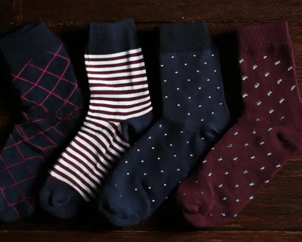 Quattro paia di calzini da uomo con fantasie diverse: rombi, righe, pois. Perfetti da abbinare a un abito elegante.