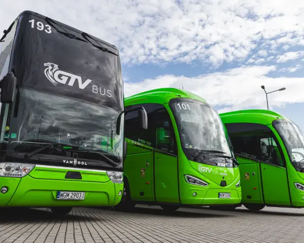 Trzy zielone autokary GTV Bus stoją obok siebie. Sprawdź neobus rozkład jazdy i zaplanuj podróż!