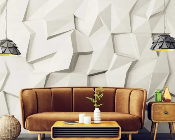Sofá marrón y mesa de centro con elementos decorativos frente a una pared con relieve que combina papel pintado y pintura.