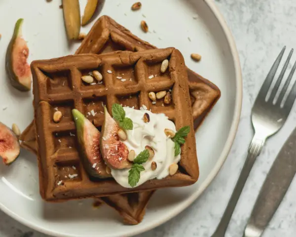 Gesunde Waffeln Rezept: Zwei Schoko-Waffeln mit Joghurt, Feigen, Pinienkernen und Minze. Ein Genuss!