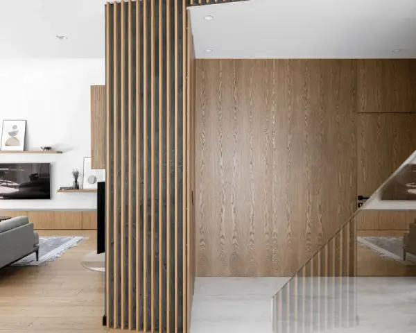 Interno di una casa stile nordico moderno, con pareti in legno, divisori a listelli e arredi minimalisti.