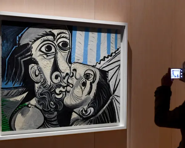 Un visitante captura con su móvil uno de los icónicos cuadros de Picasso, un beso en blanco y negro con toques de azul.