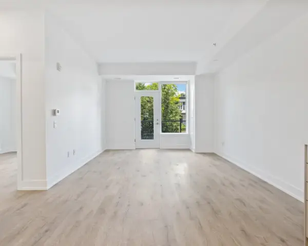 Salón luminoso con suelo de madera clara y puerta acristalada que da a un balcón. Ideal para vender piso heredado antes de 5 años.
