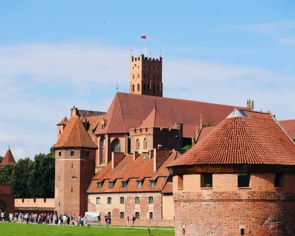 Zamek w Malborku, wpisany na listę **UNESCO Polska**, to imponująca twierdza z czerwonej cegły z charakterystycznymi wieżami i dachami.