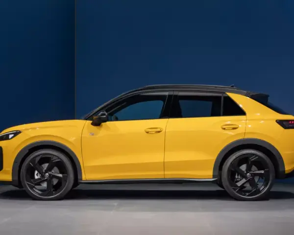 Nowy żółty Volkswagen T-Roc z czarnym dachem, widziany z boku.