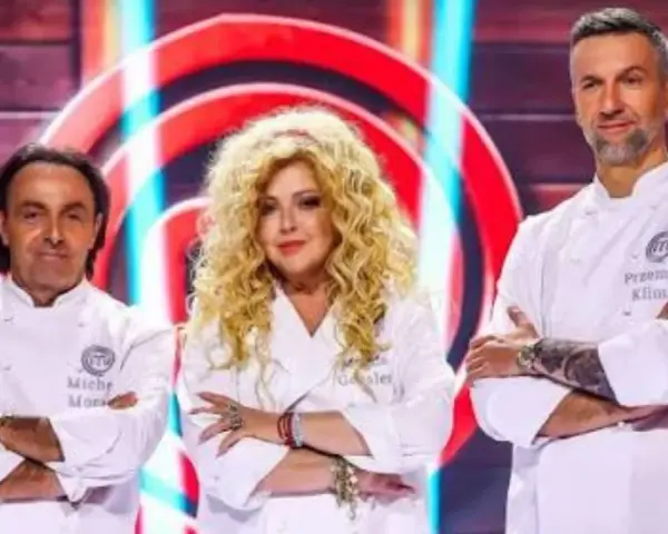 Trzech jurorów MasterChef: Michel Moran, Magda Gessler i Przemysław Klimsa, w białych fartuchach, z rękami skrzyżowanymi na piersi.