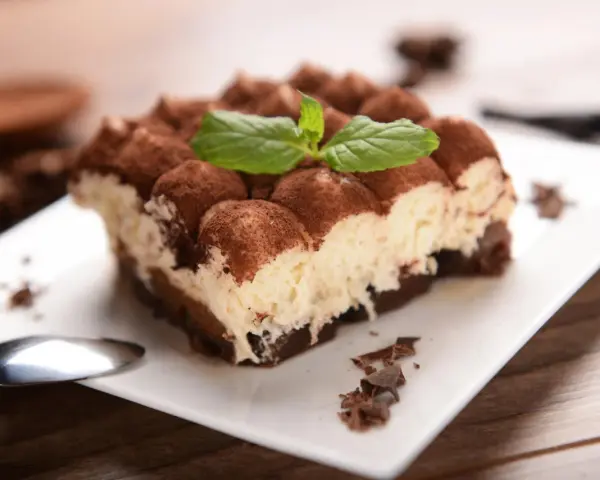 Pyszne tiramisu, posypane kakao i udekorowane miętą. Idealne na deser, choć warto pamiętać o jego tiramisu kcal.