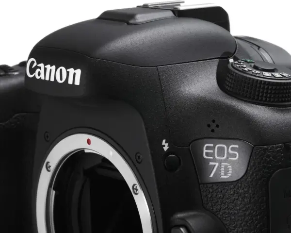 Czarne body aparatu Canon EOS 7D z widocznym obiektywem i pokrętłem trybów.