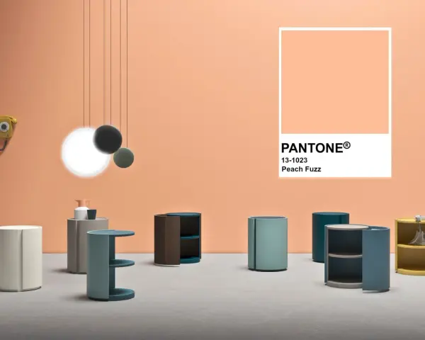 Arredamento moderno su sfondo color pesca Pantone. Tavolini cilindrici e un telefono vintage.