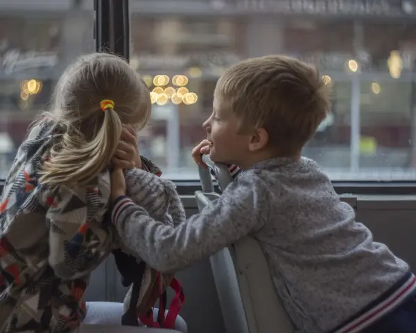 Dzieci rozmawiają przy oknie, planując kolejne atrakcje dla dzieci w Kielcach.