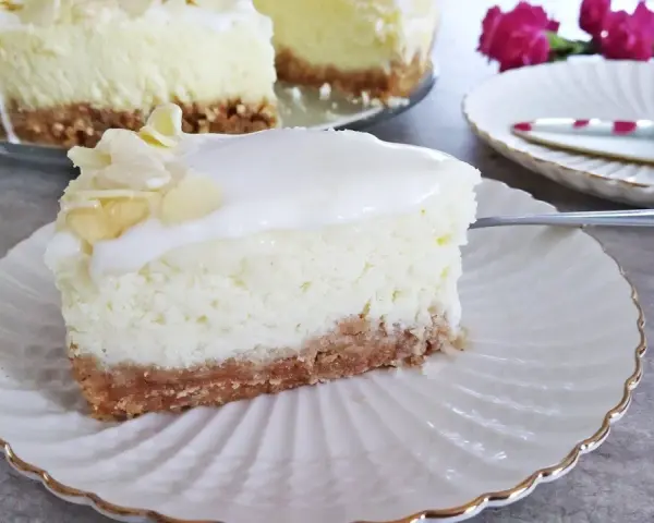 Pyszny sernik z mascarpone na kruchym spodzie, udekorowany płatkami migdałów. Idealny na deser.