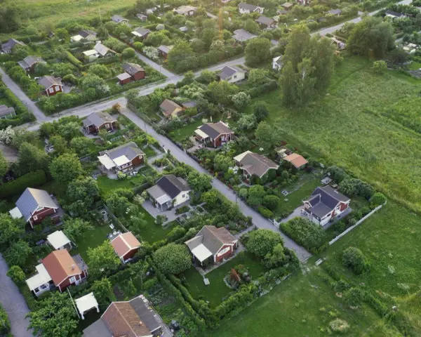 Malownicze ukształtowanie terenu z rzędem czerwonych domków i bujną zielenią.