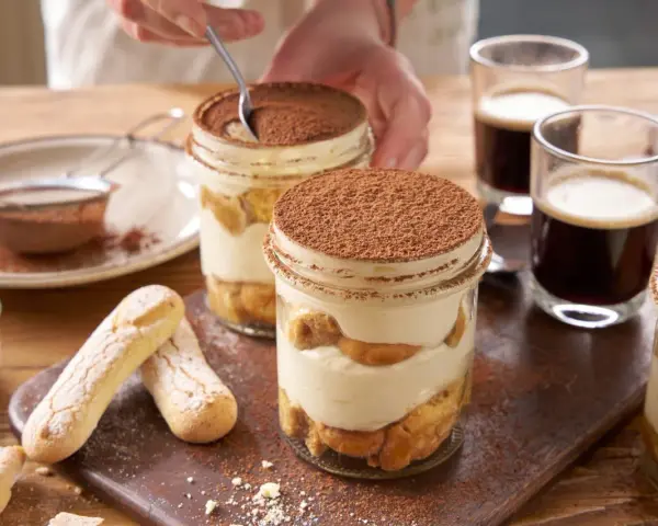 Pyszne tiramisu składniki w słoiczkach, z biszkoptami i kawą.
