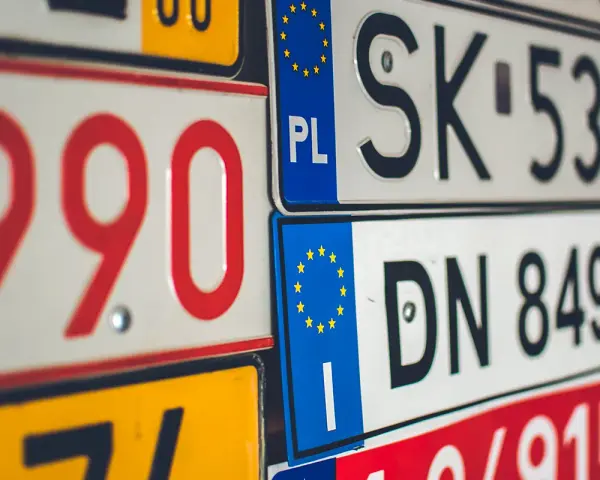 Un'opera d'arte di targhe automobilistiche europee, con numeri rossi e neri su sfondi bianchi e gialli.