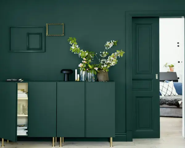 Un buffet vert sapin, des cadres dorés et noirs, des fleurs blanches et roses. Quelle couleur avec le vert sapin ? Le doré ressort magnifiquement.