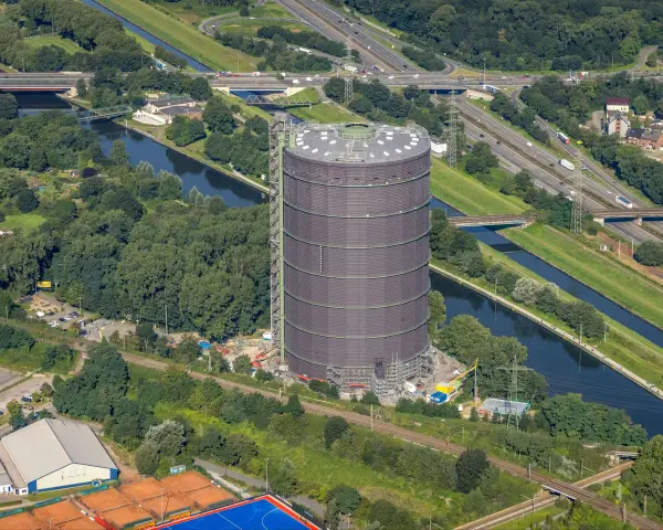 Gasometer Oberhausen aus der Vogelperspektive mit Kanal, Autobahn und Grünflächen.