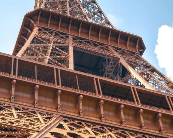 La famille Eiffel, une fortune bâtie sur le fer. Vue rapprochée de la Tour Eiffel, structure métallique complexe sous un ciel bleu.