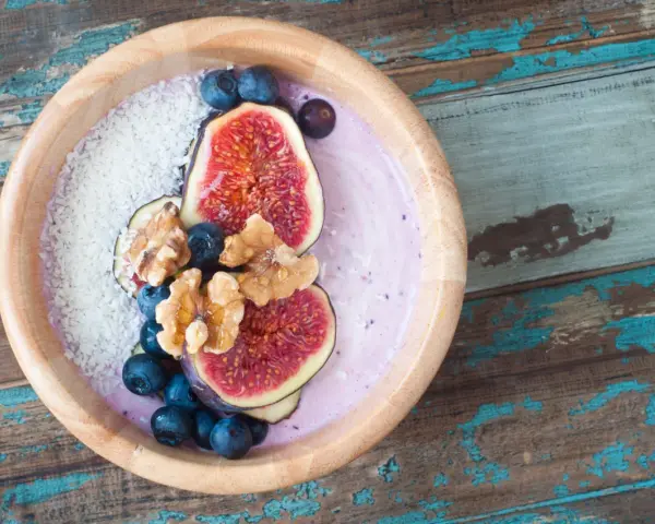 Smoothie bowl z figami, borówkami i wiórkami kokosowymi, przypominający wyglądem tradycyjny kisiel.
