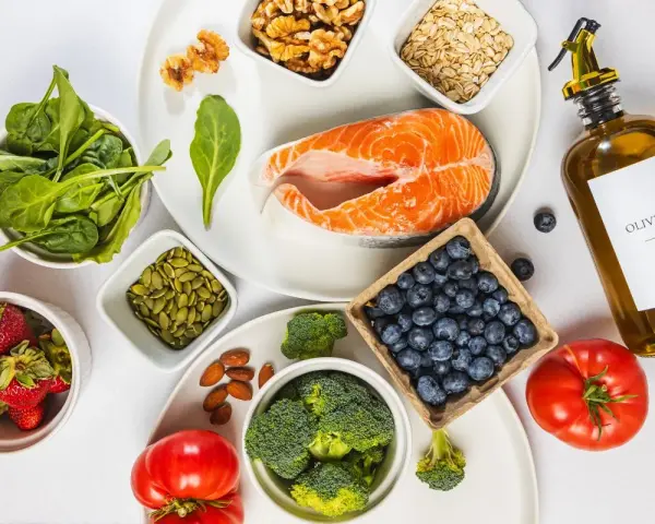 En hälsosam måltid med lax, bär, grönsaker och nötter. Denna inflammation mat är rik på omega-3 och antioxidanter.