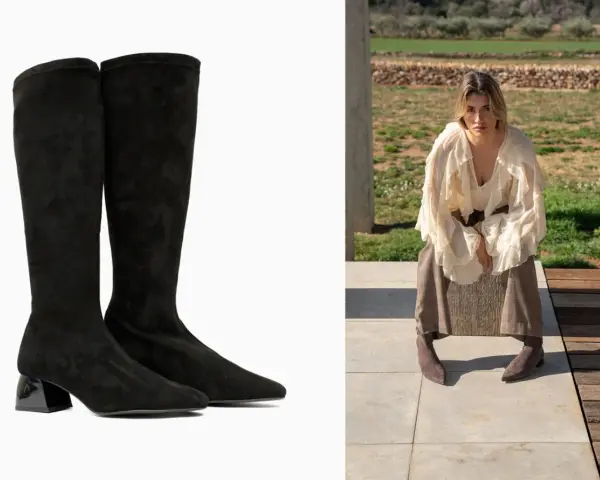 Botas negras de altura de caña con tacón brillante, combinadas con una mujer con falda y blusa voluminosa sentada al aire libre.