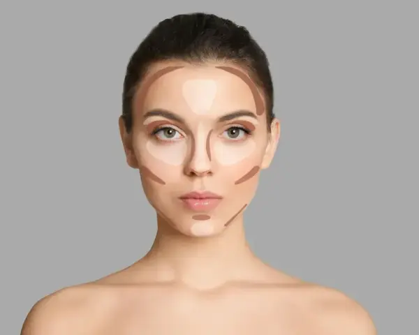 Modelka pokazuje, gdzie nakładać bronzer i rozświetlacz, by wymodelować twarz.