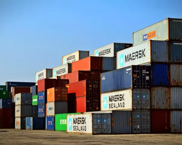 Stos kontenerów w porcie, świadectwo globalnej logistyki Rhenus. Widoczne napisy Maersk, Evergreen, Cronos.