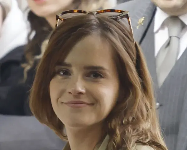Emma Watson, con occhiali da sole sulla testa, sorride. La sua espressione suggerisce una vivacità che alcuni associano all'ADHD.