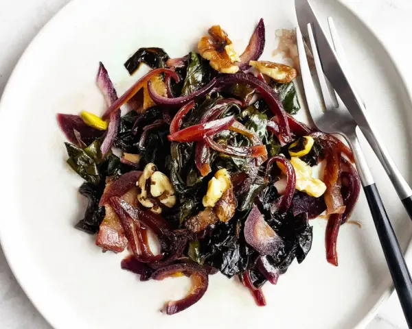 Bietole in padella con cipolla rossa e noci, un contorno saporito e colorato pronto per essere gustato.