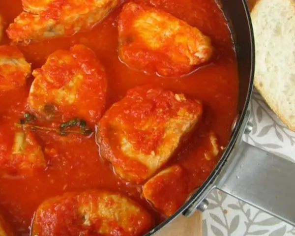 Sabroso pollo en salsa de tomate, como la receta de la abuela. Acompañado de pan crujiente.