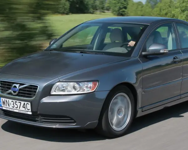 Szary Volvo S40 2.0 diesel w ruchu, z rozmazanym tłem zieleni i drogi.