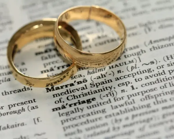 Two gold wedding rings rest on a dictionary page, highlighting the definition of "marriage" and its contrast to sexual immorality.
