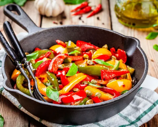 Peperoni in padella, colorati e succosi, pronti per essere gustati. Un contorno semplice e saporito.