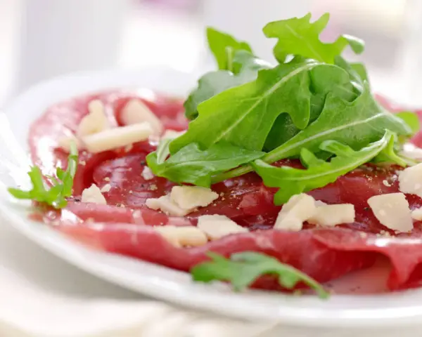 Cienkie plastry wołowiny z rukolą i parmezanem, skropione oliwą. Idealny sos do carpaccio.