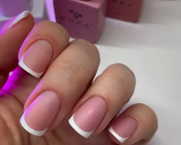 Dłonie z idealnym manicure, klasyczny french na paznokciach.