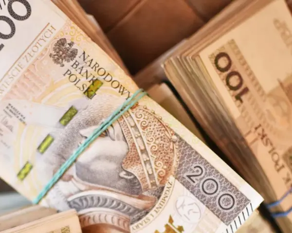 Stosy polskich banknotów 200 zł i 100 zł. Zastanawiasz się, ile zarabia sprzedawca w salonie samochodowym?