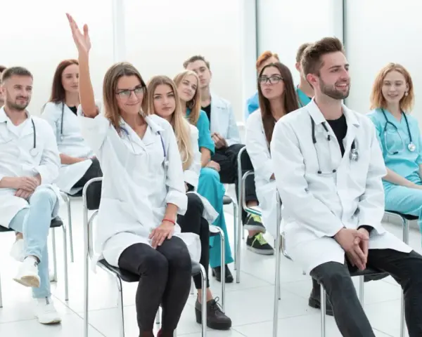Uczestnicy kursu rejestratorka medyczna, jedna osoba podnosi rękę.