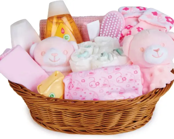 En korg fylld med rosa babyartiklar, inklusive nallar, blöjor och tvättlappar, perfekt som baby shower present.