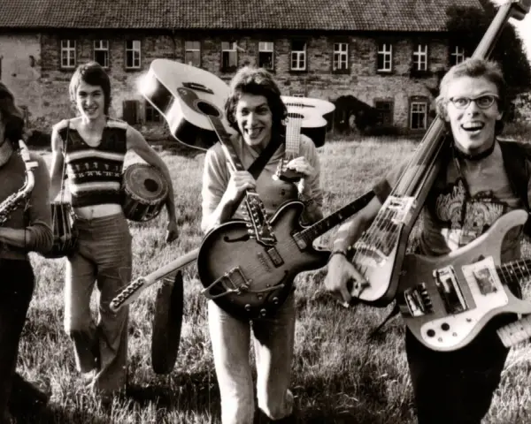 Vier Musiker mit Gitarren und Saxophon, ein Schlagzeuger. Eine Szene, die an deutsche Bands der 70er erinnert, voller Energie und Musik.